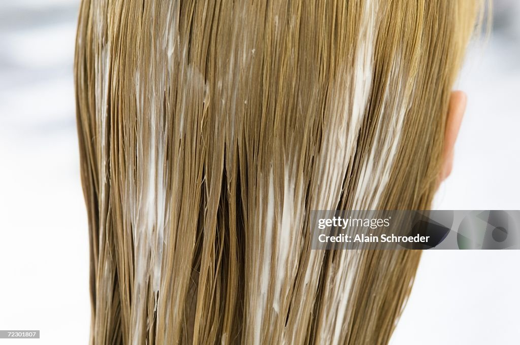 Young woman with hair mask, view from the back, close up (studio)