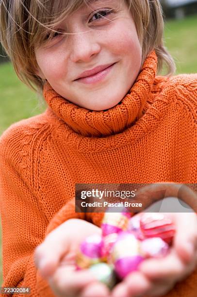 boy holding easter eggs - chocolate foil stock-fotos und bilder