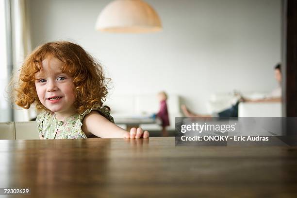 little girl looking at the camera, coffee table in the foreground - girls around table stock-fotos und bilder