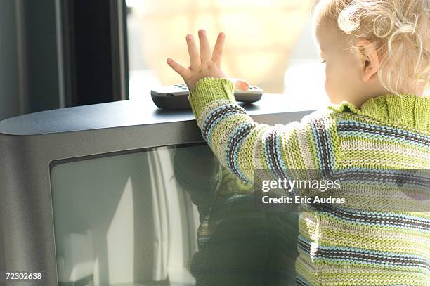 little boy taking tv remote control, rear view - dumb blonde stock pictures, royalty-free photos & images