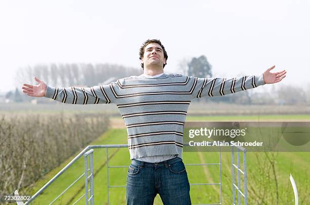 man standing on a terrace, arms outstretched - man arms outstretched stock pictures, royalty-free photos & images