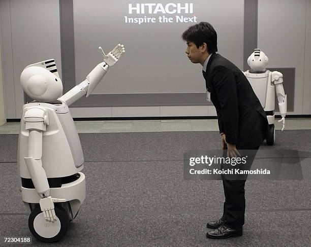 Man with Japanese electronics conglomerate Hitachi's New Humaniod Robot 'Emiew' impressed with their chat and fast moves during a demonstration on...