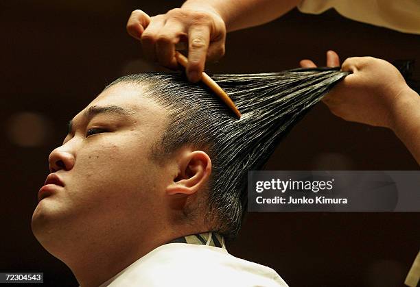 Sumo wrestler gets his topknot done during the topknot cutting ceremony of the Hawaiian-born former grand champion Musashimaru on October 2, 2004 in...