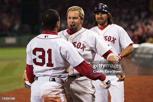 Trot Nixon and Johnny Damon of the Boston Red Sox celebrate with teammate Dave Roberts after Roberts scored the game-tying run on a single by Bill...