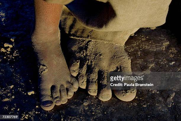 Afghani refugees living at the Pung Puti refugee camp on the outskirts of Quetta, Pakistan stand in bare feet September 29, 2001. The refugees, who...