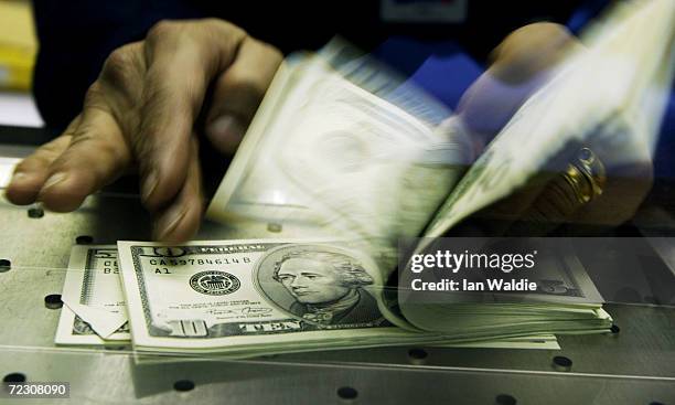 Cashier at a Travelex Bureau de Change counts U.S. Dollars in exchange for British pounds February 19, 2004 in London. The recent dramatic fall in...