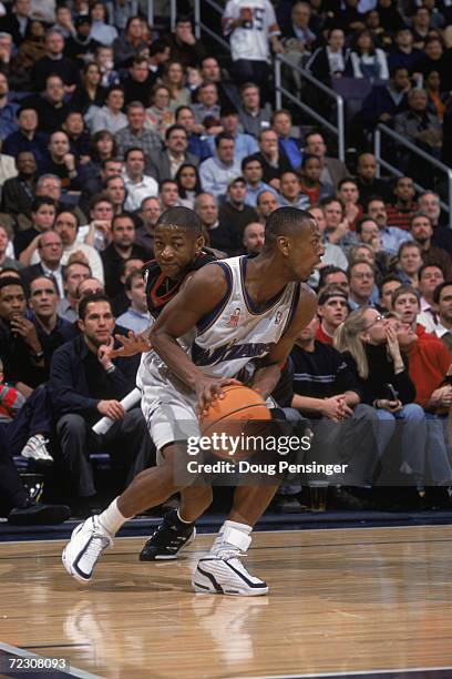 Guard Chris Whitney of the Washington Wizards holds the ball as point guard Eric Snow of the Philadelphia 76ers plays defense during the NBA game at...