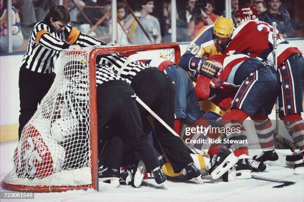 Linesmen and the referee try to break up a fight in the goal mouth net between the players of the Los Angeles Kings and Washington Capitols during...