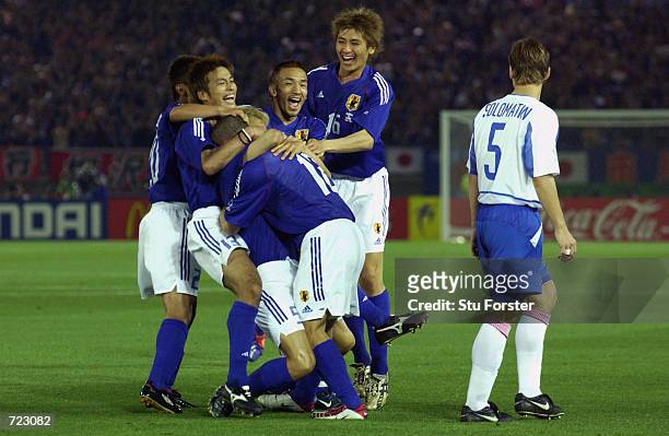 Junichi Inamoto of Japan is mobbed after scoring the winning goal during the FIFA World Cup Finals 2002 Group H match between Japan and Russia played...