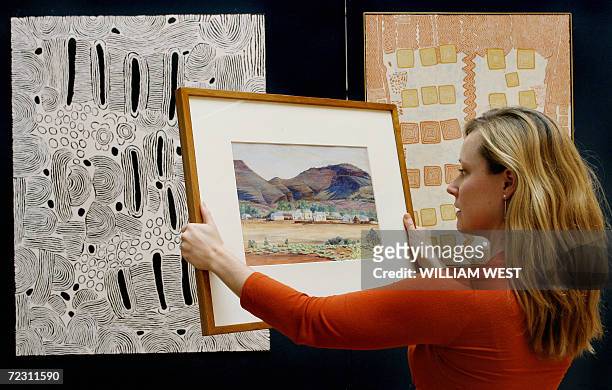 Sotheby's employee Kate Dezarnaulds holds the first painting by famous Aboriginal artist Albert Namatjira painted in 1936 and which is up for auction...