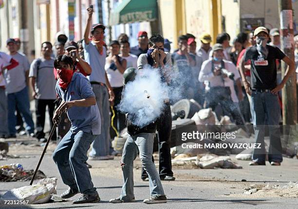 Member of the Oaxaca People's Popular Assembly shoots a firework during the second day of clashes against federal troops in Oaxaca, 30 October 2006....