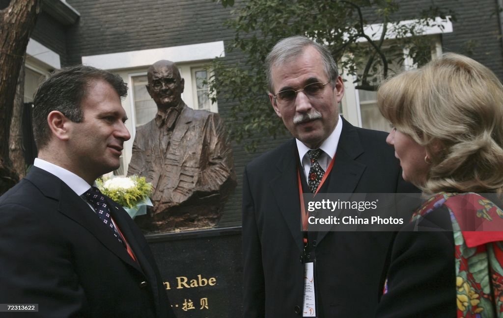 Thomas John Rabe Thomas Rabe and his wife talk in front of a sculpture of their German ...