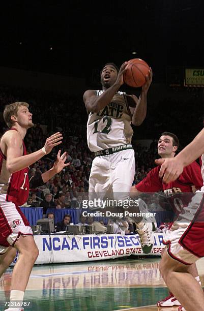 Mateen Cleaves of Michigan State University goes to the basket between Hanno Mottola and Alex Jensen of the University of Utah as the Spartans...