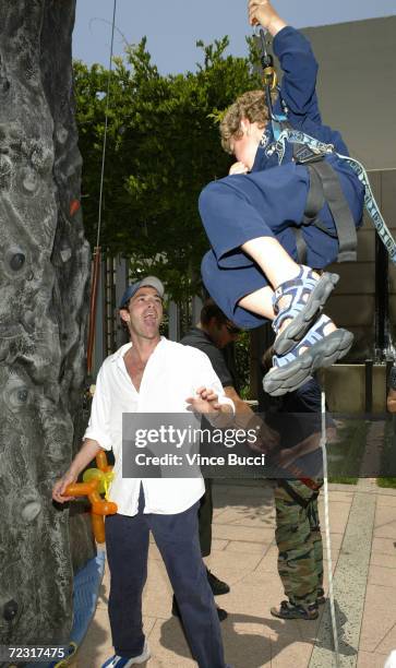 Actor Luke Perry reacts to son Jack's climbing ability at an afterparty for the premiere of "Garfield - The Movie" at the Twentieth Century Fox...