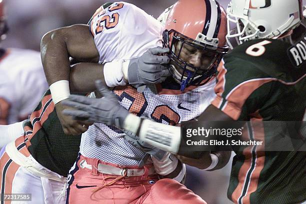 Running back Diamond Ferri of the Syracuse Orangemen is sandwiched by cornerbacks Sean Taylor and Antrel Rolle of the Miami Hurricanes during the Big...