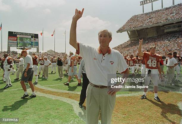 Head coach John Mackovic of the Texas Longhorns along with the rest of the team members salute with the University's tradmark "hook'em horns" during...