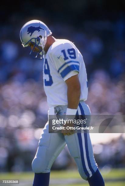 Quarterback Scott Mitchell of the Detroit Lions hangs his head in frustration as he walks off the football field following an unsuccessful play in...