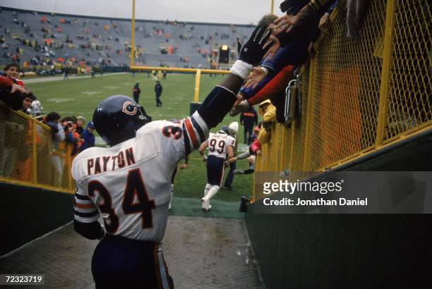 Walter Payton of the Chicago Bears shakes hands with fans before a game against the Green Bay Packers in Green Bay, Wisconsin.