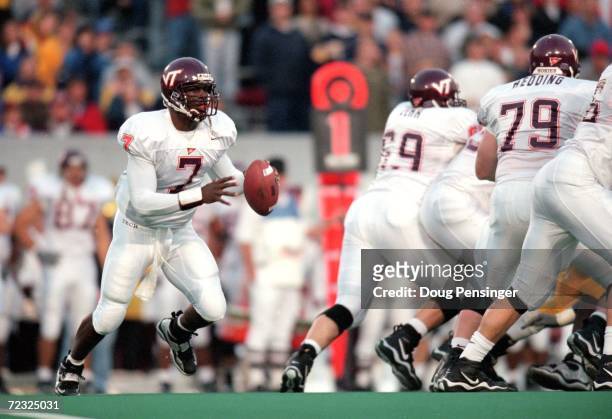 Michael Vick of the Virginia Tech Hokies looks to pass the ball during a game against the West Virginia Mountaineers at Mountaineer Field in...