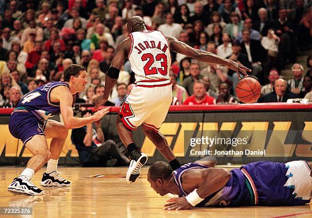 Michael Jordan of the Chicago Bulls dribbles the ball as he is guarded by Jeff Hornacek of the Utah Jazz during the NBA Final game at the United...