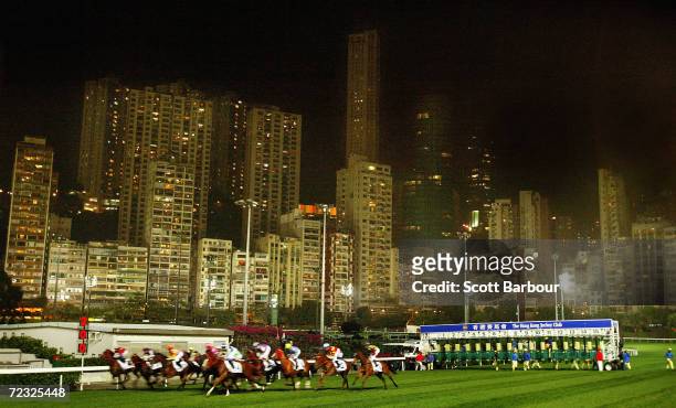 Horses race past the city skyline during race 7 of the International Jockeys' Championship Races held at Happy Valley Racecourse December 10, 2003 in...