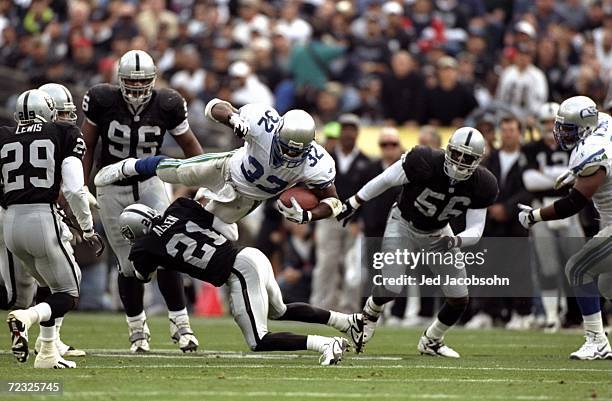 Running back Ricky Watters of the Seattle Seahawks is tackled by Eric Allen of the Oakland Raiders during a game at the Oakland Coliseum in Oakland,...