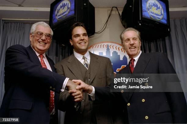 Mike Piazza of the New York Mets shakes hands with Mets Owners Fred Wilpon and Nelson Doubleday during a Press Conference in New York City, New York....