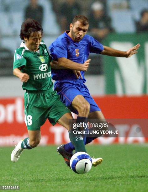 Jeonju , REPUBLIC OF KOREA: South Korea's Jeonbuk Motors player Chung Jung-Kwan fights with Syria's Al Karama player Jehad Kassab during the first...