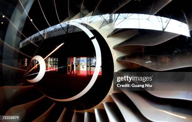 Reflection view by a displaying Rolls-Royce aircraft engines shows an exhibitor walking into Airshow China 2006 on November 1, 2006 in Zhuhai, south...