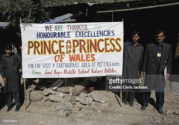 Locals stand beside a sign welcoming Camilla, Duchess of Cornwall and Prince Charles, Prince of Wales, on November 01, 2006 in Pattika, Kashmir...
