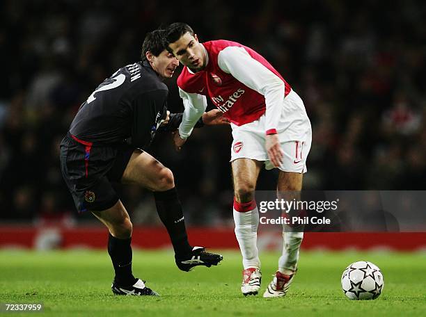 Robin Van Persie of Arsenal is challenged by Evgeni Aldonin of CSKA Moscow during the UEFA Champions League Group G match between Arsenal and CSKA...