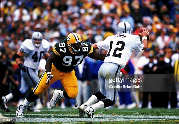 Cletidus Hunt of the Green Bay Packers moves to tackle quarterback Rich Gannon of the Oakland Raiders at Lambeau Field in Green Bay, Wisconsin. The...