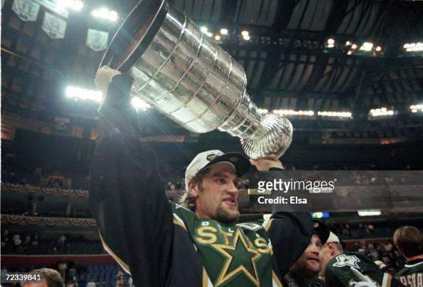 Captain Derian Hatcher of the Dallas Stars carries the Stanley Cup after the Stanley Cup Final game against the Buffalo Sabres at the Marine Midland...
