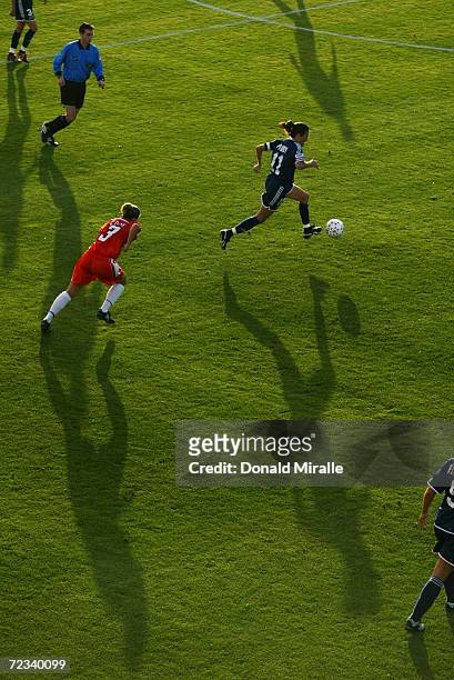 Midfielder Julie Foudy of the San Diego Spirit drives the ball past midfielder Ann Cook of San Jose CyberRays during the WUSA match at Torero Stadium...