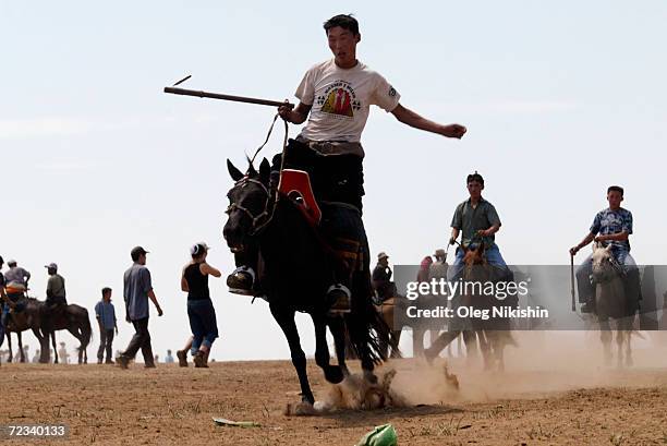 Mongolian nomad men head to watch a horse race on the second day of the Nadam festival July 12, 2003 South of Ulan Bator, Mongolia. The Nadam is an...