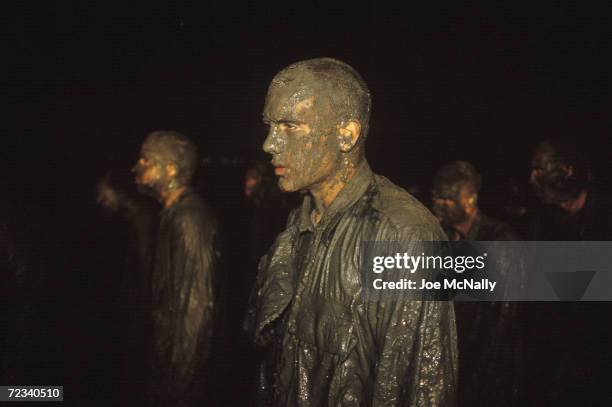 Navy Seal trainees stand at attention after crawling through mud and being subjected to frigid Pacific water in this undated photo taken in 2000 at...