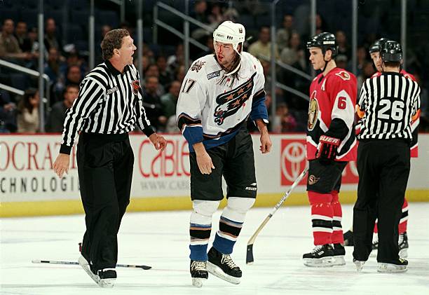 Chris Simon of the Washington Capitals talks with Linesman Kevin Collins during the game against the Ottowa Senators at the MCI Center in Washington,...