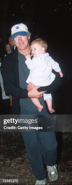 Actor Richard Gere carries his baby son Homer James Jigme Gere, August 19, 2000 at the Watermill Center 7th Annual Summer Gala Benefit in Watermill,...