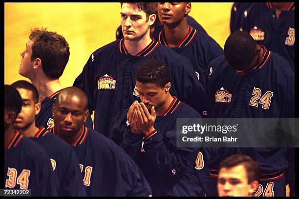 Point guard Mahmoud Abdul-Rauf of the Denver Nuggets stands in prayer during the singing of the National Anthem before the Nuggets game against the...