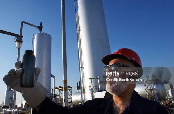 An oil worker checks a sample of crude at the Burgan oil field January 13, 2003 in Central Kuwait. The oil field, the largest in the world, was...