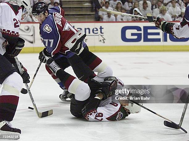 Center Jeremy Roenick of the Phoenix Coyotes ends up upside down as defenseman Ray Bourque of the Colorado Avalanche moves to block a shot in the...