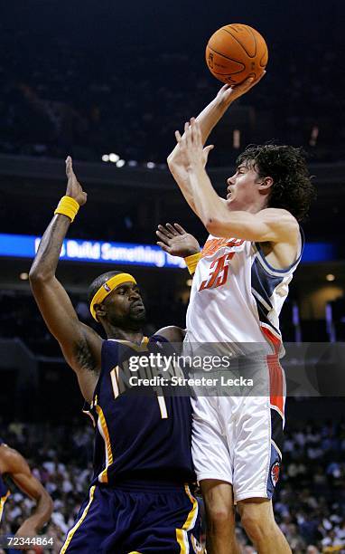 Stephen Jackson of the Indiana Pacers watches as Adam Morrison of the Charlotte Bobcats shoots the ball during their game on opening night on...