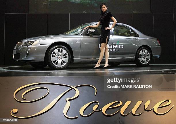 Model stands next to a Chinese made Roewe car from the SAIC Motor Corp at the China International Industry Fair in Shanghai, 02 November 2006. SAIC...