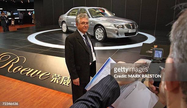 German businessman gets his photo taken in front of a Chinese-made Roewe car from the SAIC Motor Corp at the China International Industry Fair in...