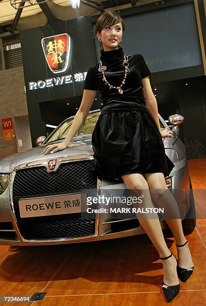 Chinese model poses next to a Chinese made Roewe car from the SAIC Motor Corp at the China International Industry Fair in Shanghai, 02 November 2006....