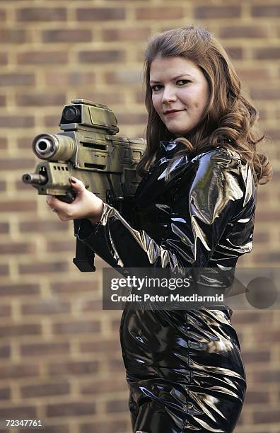 Leonie Ashfield from Christie's auctioneers poses with a prop tank buster gun from 'Die Another Day' during promotion of a sale of weapons from James...
