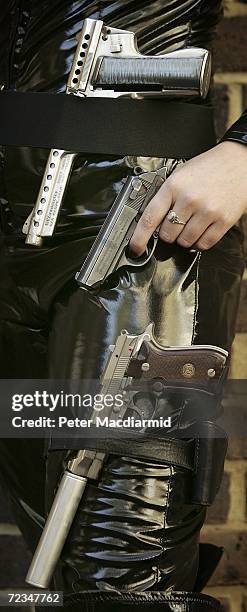 Leonie Ashfield from Christie's auctioneers poses with prop guns during promotion of a sale of weapons from James Bond films on November 2, 2006 in...