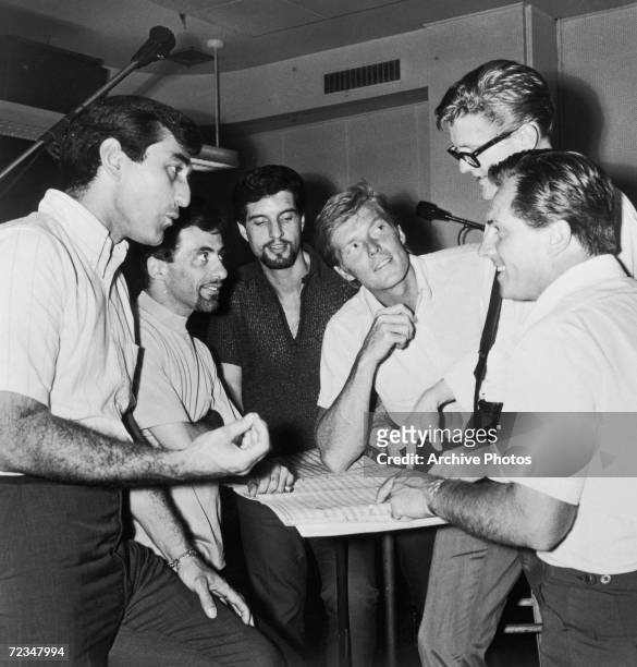 Italian-American vocal group The Four Seasons go over an arrangement during a recording session, circa 1966. Left to right: Joe Long, Frankie Valli,...