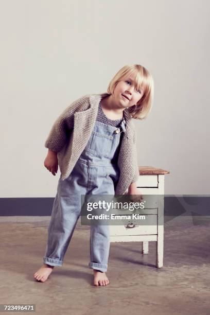 mischievous girl opening drawer of old cabinet - ボブヘア ストックフォトと画像