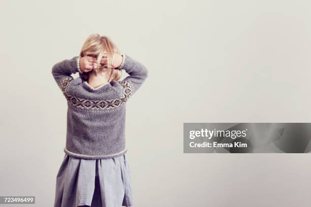 rear view of girl fidgeting with blond hair - hand in hair stock pictures, royalty-free photos & images
